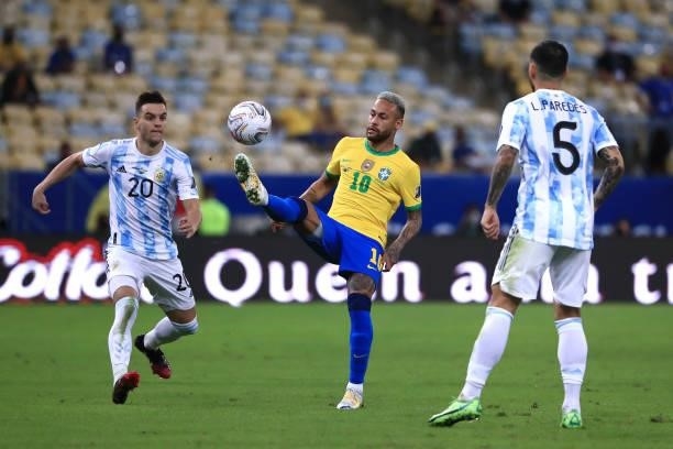 Neymar Jr. Of Brazil kicks the ball against Giovani Lo Celso and Leandro Paredes of Argentina during the final of Copa America Brazil 2021 between...