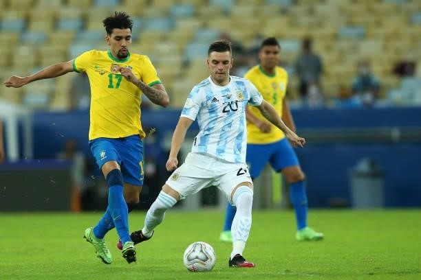 Giovani Lo Celso of Argentina kicks the ball against Lucas Paqueta of Brazil during the final of Copa America Brazil 2021 between Brazil and...