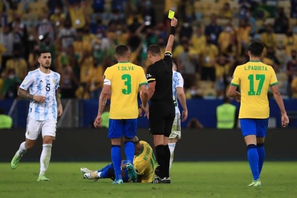 Referee Esteban Ostojich shows a yellow card to Giovani Lo Celso of Argentina as Neymar Jr. Of Brazil reacts after suffering an injury during the...