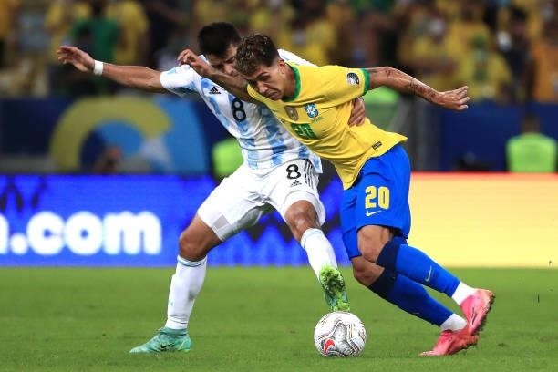 Roberto Firmino of Brazil fights for the ball with Marcos Acuña of Argentina during the final of Copa America Brazil 2021 between Brazil and...