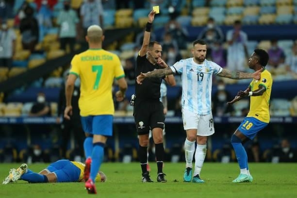 Referee Esteban Ostojich shows a yellow card to Nicolas Otamendi of Argentina during the final of Copa America Brazil 2021 between Brazil and...