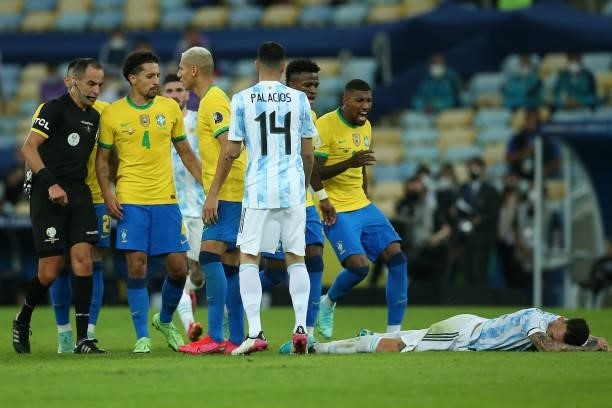Nicolas Otamendi of Argentina lays on the pitch as Marquinhos of Brazil and teammates react during the final of Copa America Brazil 2021 between...