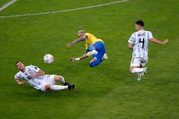 Neymar Jr. Of Brazil kicks the ball against Guido Rodriguez and Gonzalo Montiel of Argentina during the final of Copa America Brazil 2021 between...