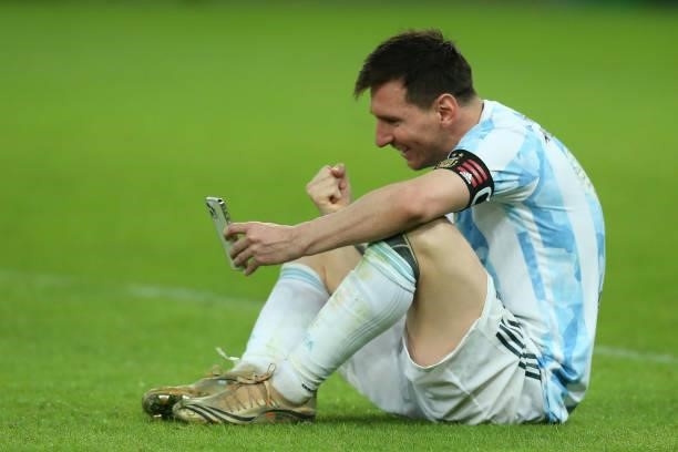 Lionel Messi of Argentina celebrates as he talks on his phone with his family after winning the final of Copa America Brazil 2021 between Brazil and...