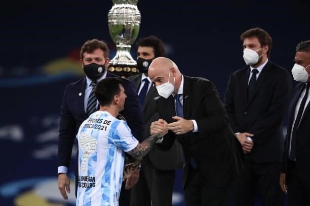 Lionel Messi of Argentina greets President of FIFA Gianni Infantino as he receives his medal after winning the final of Copa America Brazil 2021...