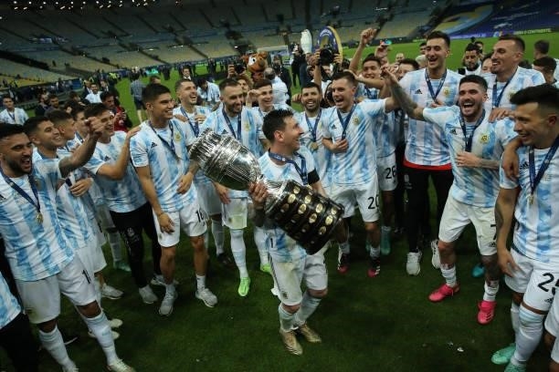 Lionel Messi of Argentina smiles with the trophy as he celebrates with teammates after winning the final of Copa America Brazil 2021 between Brazil...