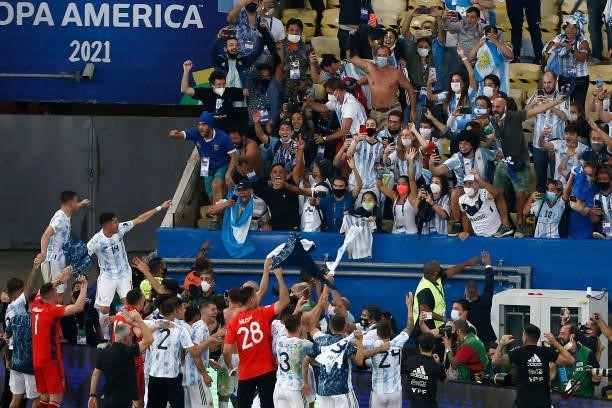 Players of Argentina celebrate with fans after winning the final of Copa America Brazil 2021 between Brazil and Argentina at Maracana Stadium on July...