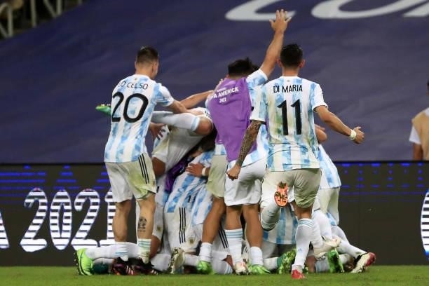 Giovani Lo Celso and Angel Di Maria of Argentina jump to celebrate with their captain Lionel Messi after winning the final of Copa America Brazil...