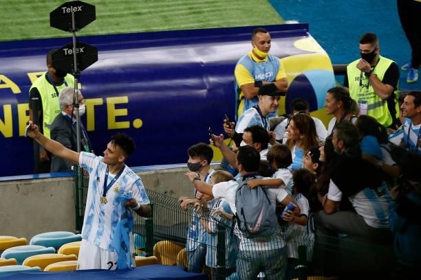 Lautaro Martinez of Argentina takes a selfie with fans after winning the final of Copa America Brazil 2021 between Brazil and Argentina at Maracana...