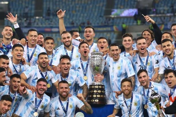 Lionel Messi and Angel Di Maria of Argentina along with teammates pose with the trophy after winning the final of Copa America Brazil 2021 between...