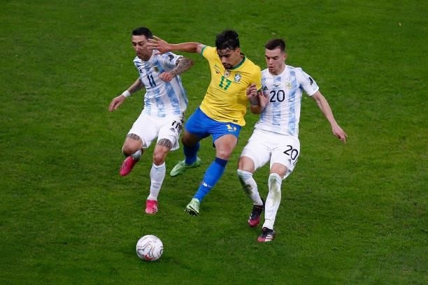 Lucas Paqueta of Brazil fights for the ball with Angel Di Maria and Giovani Lo Celso of Argentina during the final of Copa America Brazil 2021...