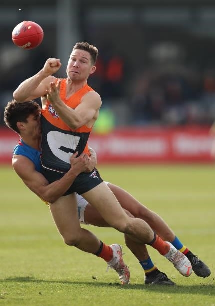 Toby Greene of the Giants handballs as he is tackled during the round 17 AFL match between Greater Western Sydney Giants and Gold Coast Suns at Mars...