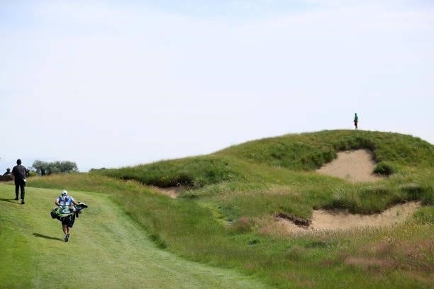Patrick Reed of the United States passes a bunker on the fourth hole during a practice round for The 149th Open at Royal St George’s Golf Club on...