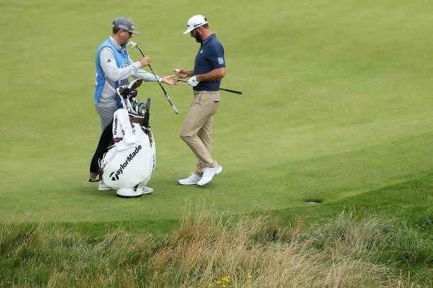 Dustin Johnson of the United States speaks with caddie during a practice round for The 149th Open at Royal St George’s Golf Club on July 11, 2021 in...