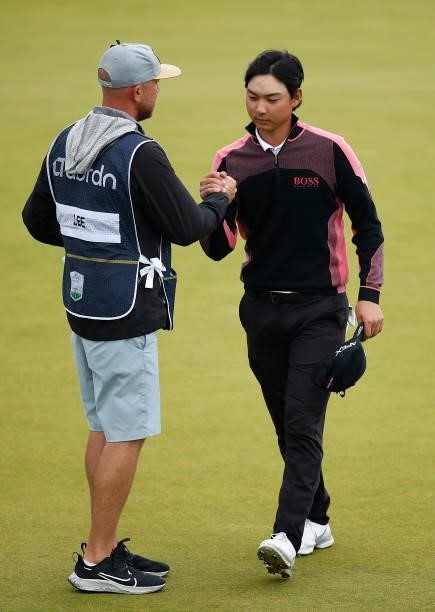 Min Woo Lee of Australia shakes hands with his caddie on the18th green during Day Four of the abrdn Scottish Open at The Renaissance Club on July 11,...