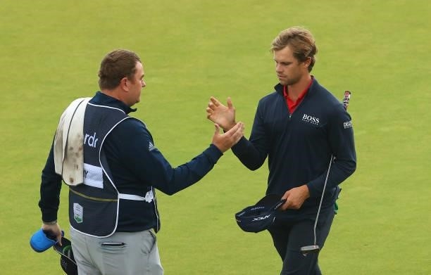 Thomas Detry of Belgium shakes hands with his caddie Michael Burrow on the 18th green during Day Four of the abrdn Scottish Open at The Renaissance...