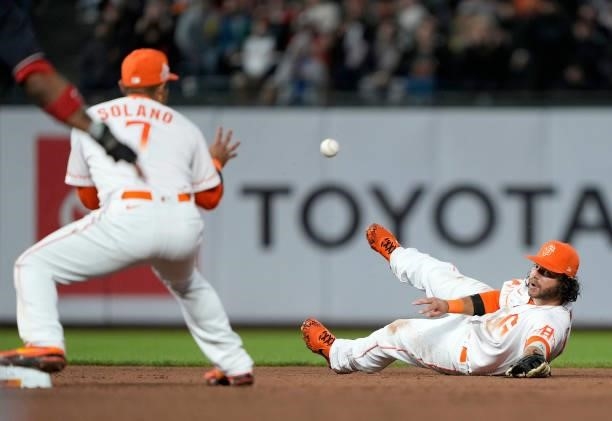 Brandon Crawford of the San Francisco Giants starts the double-play from the ground using his glove to toss the ball to Donovan Solano against the...