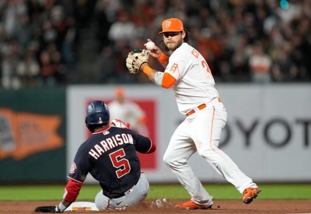 Brandon Crawford of the San Francisco Giants completes the double-play throwing over the top of Josh Harrison of the Washington Nationals in the top...