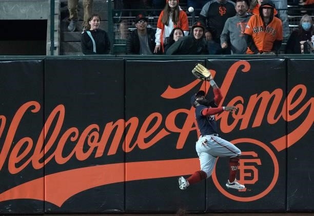 Josh Harrison of the Washington Nationals leaps at the wall and watches the ball get over his head for a double off the bat of Curt Casali of the San...
