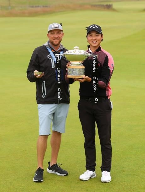 Min Woo Lee of Australia and caddie William Harke celebrate with the trophy after winning the abrdn Scottish Open at The Renaissance Club on July 11,...