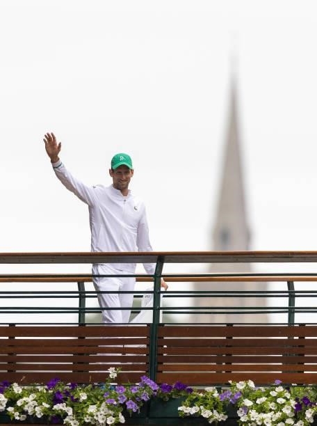 Novak Djokovic of Serbia waves to the crowds as he walks across the bridge over St Mary's Walk during Day Thirteen of The Championships - Wimbledon...