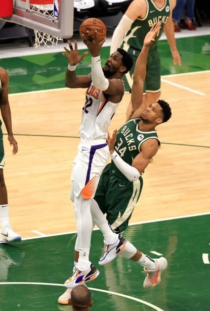Deandre Ayton of the Phoenix Suns goes up for a layup over Giannis Antetokounmpo of the Milwaukee Bucks during the first half in Game Three of the...