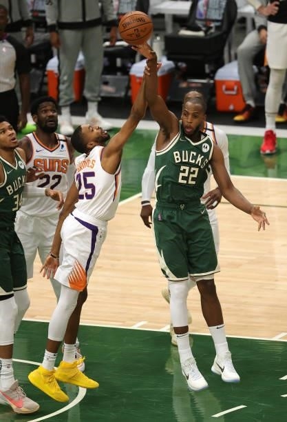Khris Middleton of the Milwaukee Bucks passes the ball as Deandre Ayton of the Phoenix Suns defends during the first half in Game Three of the NBA...