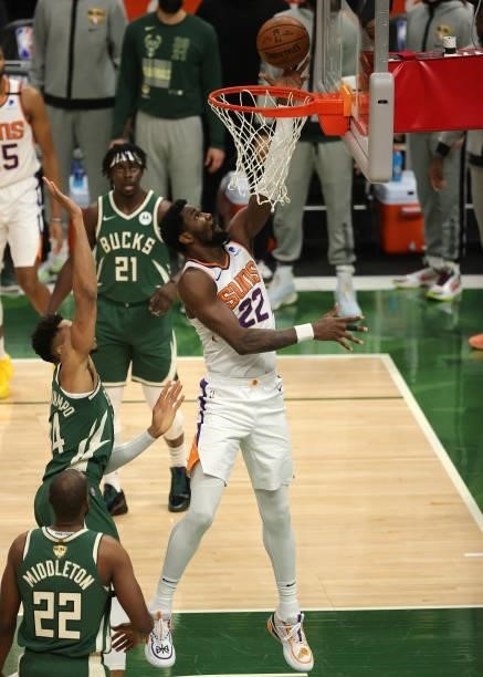 Deandre Ayton of the Phoenix Suns drives past Giannis Antetokounmpo of the Milwaukee Bucks for a layup during the first half in Game Three of the NBA...
