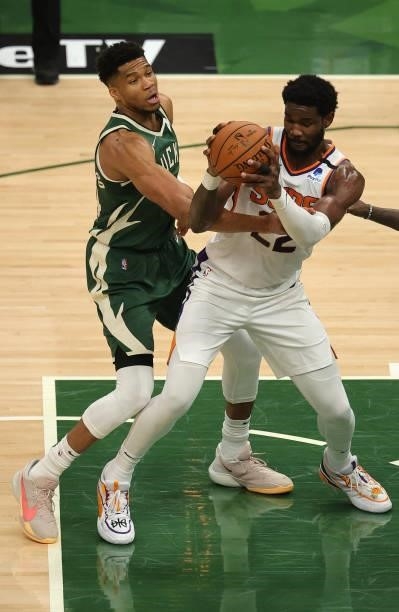 Deandre Ayton of the Phoenix Suns looks to pass as Giannis Antetokounmpo of the Milwaukee Bucks attempts to steal the ball during the first half in...