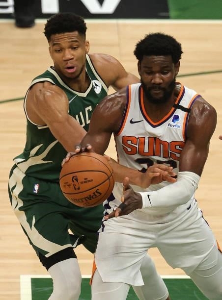 Giannis Antetokounmpo of the Milwaukee Bucks attempts to steal the ball from Deandre Ayton of the Phoenix Suns during the first half in Game Three of...