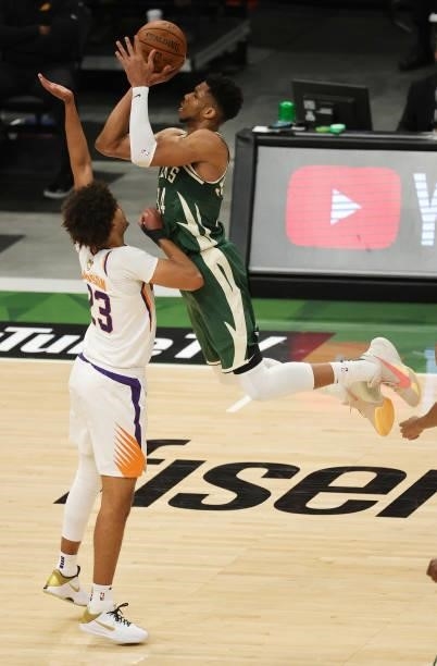 Giannis Antetokounmpo of the Milwaukee Bucks takes a jump shot over Cameron Johnson of the Phoenix Suns during the first half in Game Three of the...