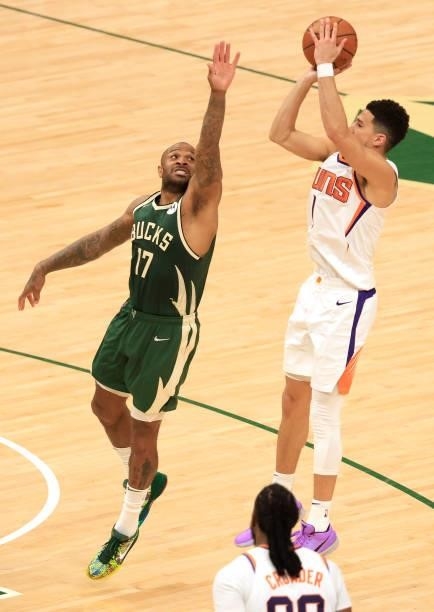 Devin Booker of the Phoenix Suns takes a shot over P.J. Tucker of the Milwaukee Bucks during the first half in Game Three of the NBA Finals at Fiserv...