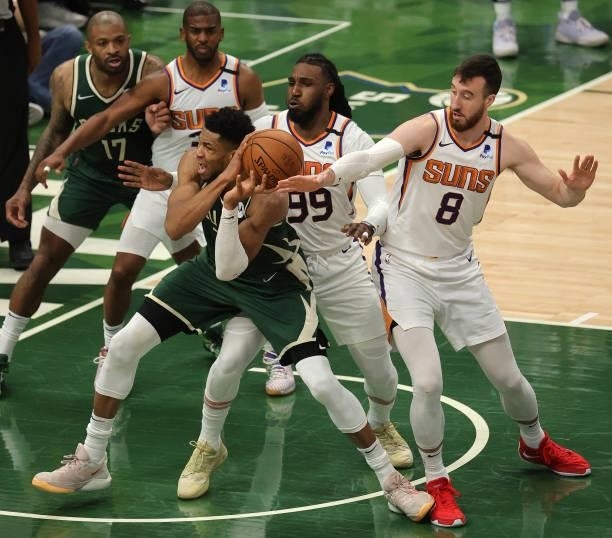 Giannis Antetokounmpo of the Milwaukee Bucks battles for possession of the ball with Jae Crowder and Frank Kaminsky of the Phoenix Suns during the...