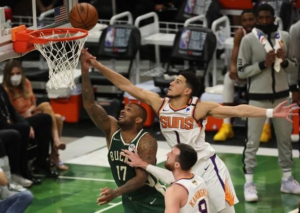 Devin Booker of the Phoenix Suns attempts to block a shot by P.J. Tucker of the Milwaukee Bucks during the first half in Game Three of the NBA Finals...
