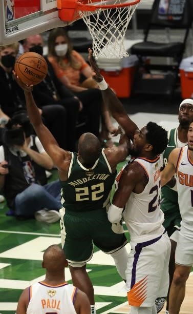 Khris Middleton of the Milwaukee Bucks goes up for a shot against Deandre Ayton of the Phoenix Suns during the first half in Game Three of the NBA...