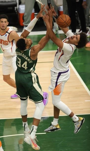 Giannis Antetokounmpo of the Milwaukee Bucks and Cameron Johnson of the Phoenix Suns battle for possession of a rebound during the second half in...