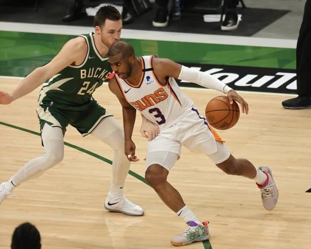 Chris Paul of the Phoenix Suns drives past Pat Connaughton of the Milwaukee Bucks during the second half in Game Three of the NBA Finals at Fiserv...