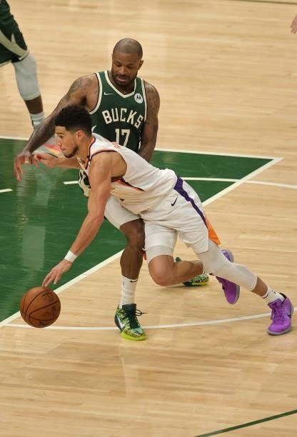 Devin Booker of the Phoenix Suns attempts to drive past P.J. Tucker of the Milwaukee Bucks during the second half in Game Three of the NBA Finals at...