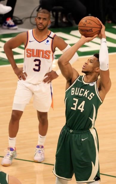 Giannis Antetokounmpo of the Milwaukee Bucks takes a free throw as Chris Paul of the Phoenix Suns looks on during the second half in Game Three of...