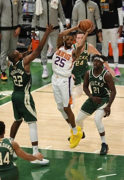 Mikal Bridges of the Phoenix Suns looks to pass as Khris Middleton and Jrue Holiday of the Milwaukee Bucks defend during the second half in Game...