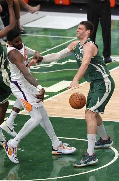 Brook Lopez of the Milwaukee Bucks and Deandre Ayton of the Phoenix Suns battle for possession of the ball during the second half in Game Three of...