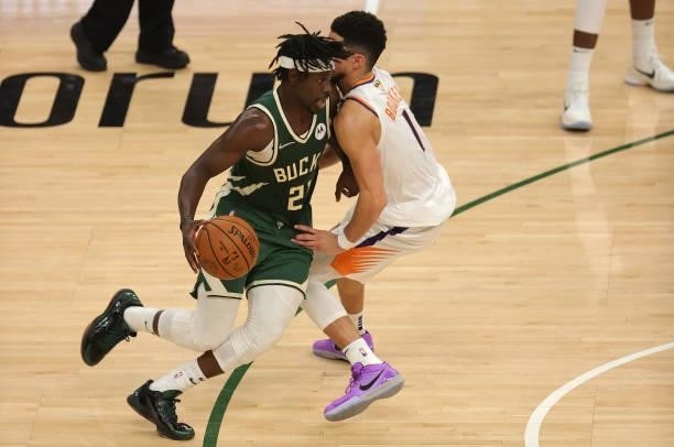Jrue Holiday of the Milwaukee Bucks drives to the basket against Devin Booker of the Phoenix Suns during the second half in Game Three of the NBA...