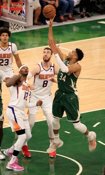Giannis Antetokounmpo of the Milwaukee Bucks shoots over Torrey Craig and Frank Kaminsky of the Phoenix Suns during the second half in Game Three of...