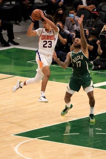 Cameron Johnson of the Phoenix Suns looks to pass as he drives into the lane against P.J. Tucker of the Milwaukee Bucks during the second half in...