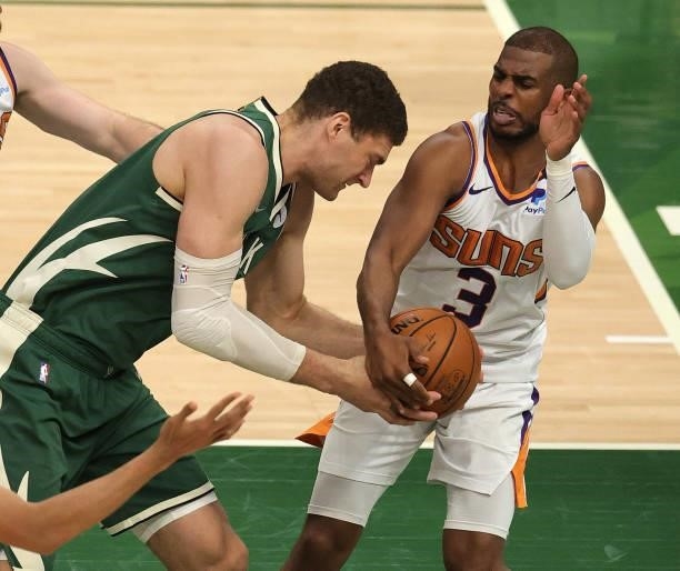 Chris Paul of the Phoenix Suns attempts to strip the ball from Brook Lopez of the Milwaukee Bucks during the second half in Game Three of the NBA...