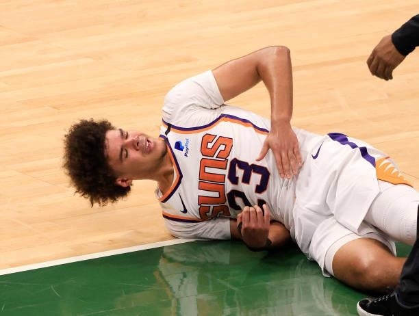Cameron Johnson of the Phoenix Suns reacts after going down hard during the second half in Game Three of the NBA Finals against the Milwaukee Bucks...
