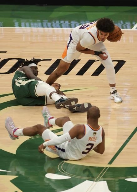 Cameron Johnson of the Phoenix Suns grabs a loose ball against Jrue Holiday of the Milwaukee Bucks during the second half in Game Three of the NBA...