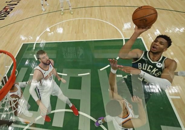 Giannis Antetokounmpo of the Milwaukee Bucks shoots over Devin Booker of the Phoenix Suns at Fiserv Forum on July 11, 2021 in Milwaukee, Wisconsin.