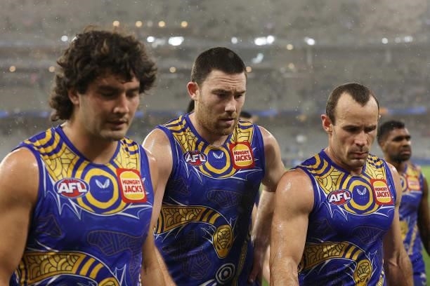 Tom Barrass, Jeremy McGovern and Shannon Hurn of the Eagles walk from the field after being defeated during the round 17 AFL match between the West...