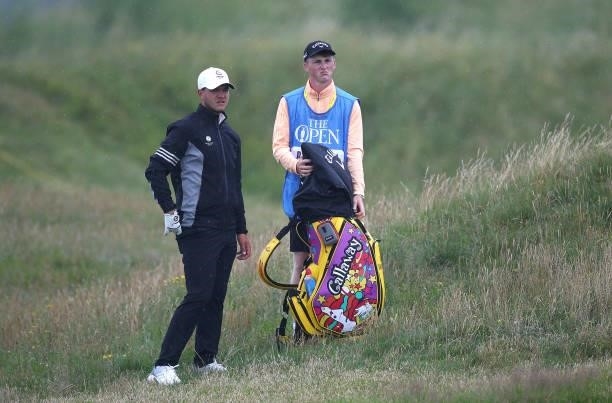 Sam Bairstow of England looks on with his caddie during a practice round ahead of The 149th Open at Royal St George’s Golf Club on July 12, 2021 in...